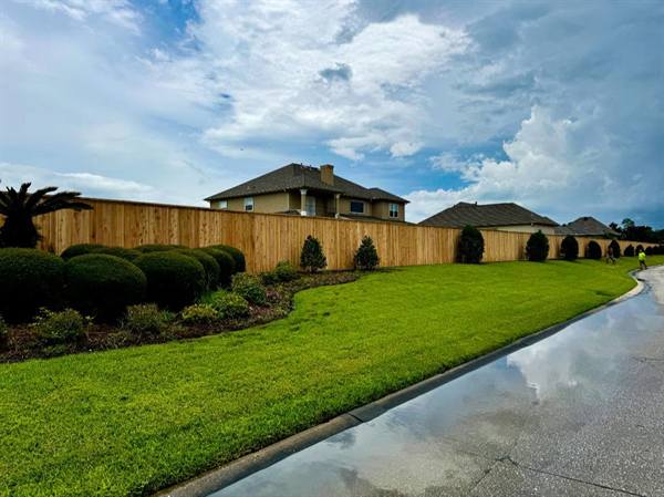 Cedar privacy fence with lattice top curving along a landscaped corner lot