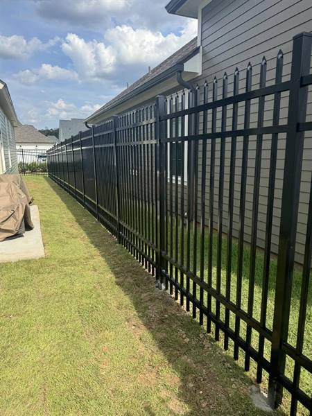 Black aluminum spear-top fence along a side yard