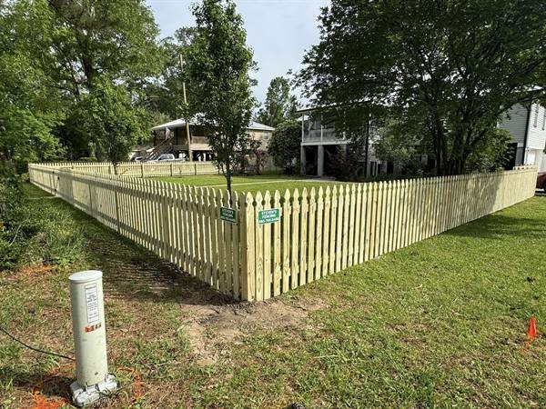 New treated pine picket fence around a corner yard