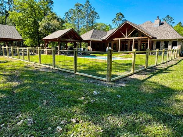 Wood-framed wire fence around a backyard pool and pavilion