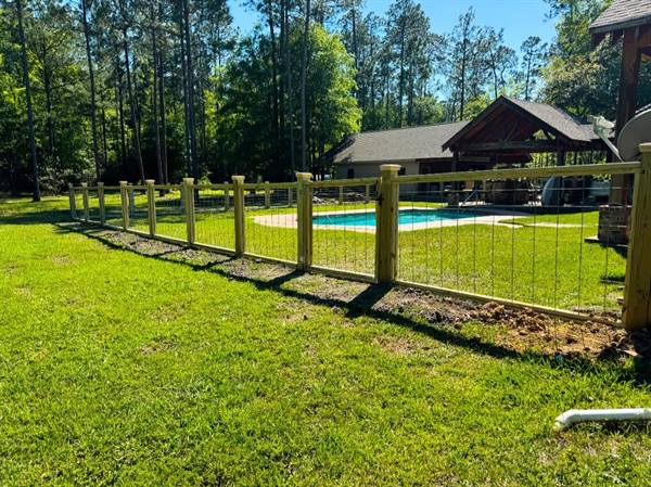 Wood-post and wire fence enclosing a pool and pavilion