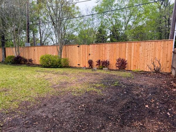 Cedar privacy fence with top cap along a backyard