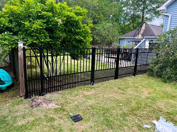 Black aluminum fence with gate in a backyard