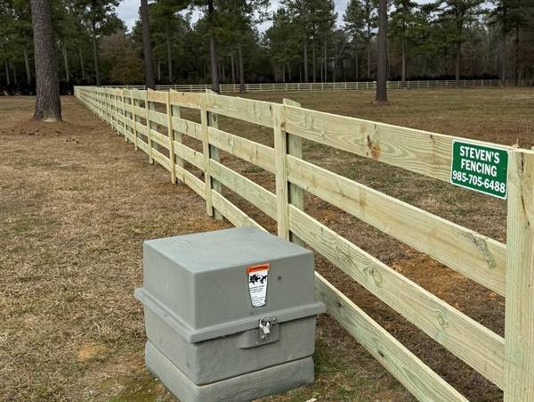 Four-rail pasture fence with the Steven's Fencing sign