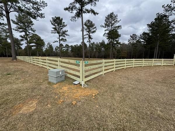 Corner of a four-rail pasture fence on acreage