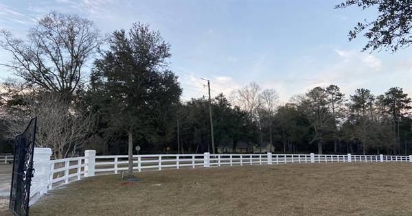White three-rail fence along the road at sunrise