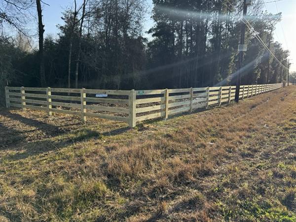 Five-rail pasture fence along a rural road