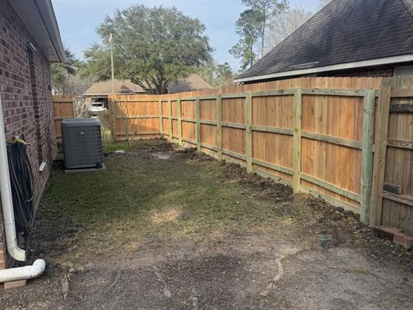 Frame side of a treated pine privacy fence along a side yard