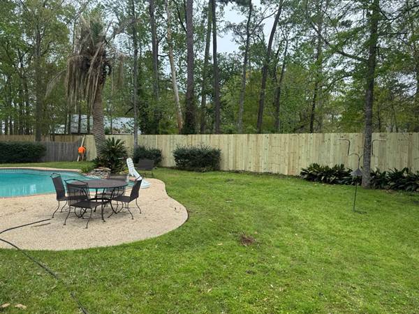 Treated pine privacy fence behind a backyard pool