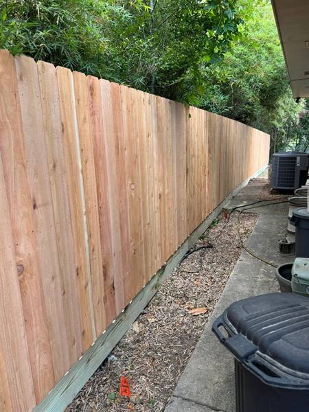 Cedar privacy fence curving along a narrow side yard