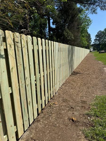 Shadowbox treated pine fence along a roadside