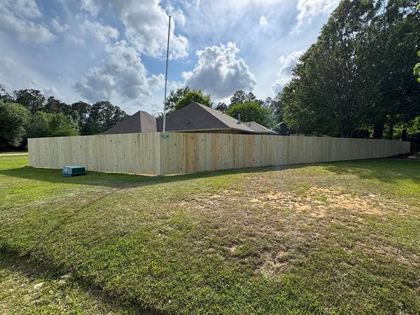 Treated pine privacy fence wrapping a corner lot