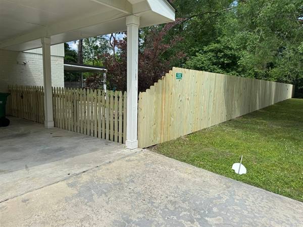 Picket fence transitioning to privacy fence beside a carport