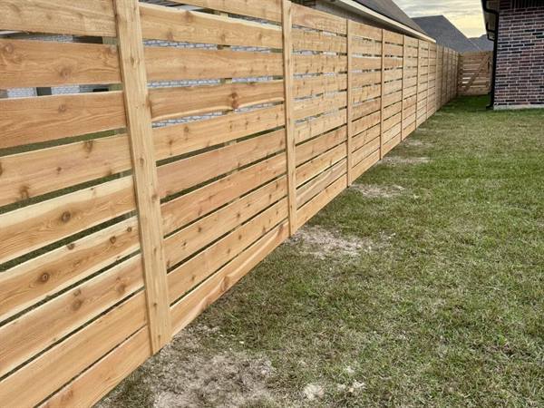 Modern horizontal-board cedar fence along a side yard