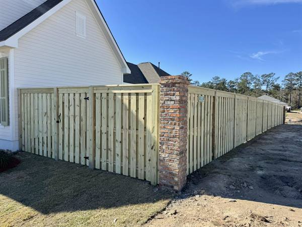 Shadowbox pine fence with brick columns at a new home