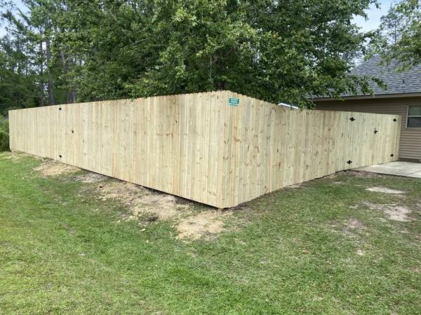 Treated pine privacy fence wrapping a backyard corner