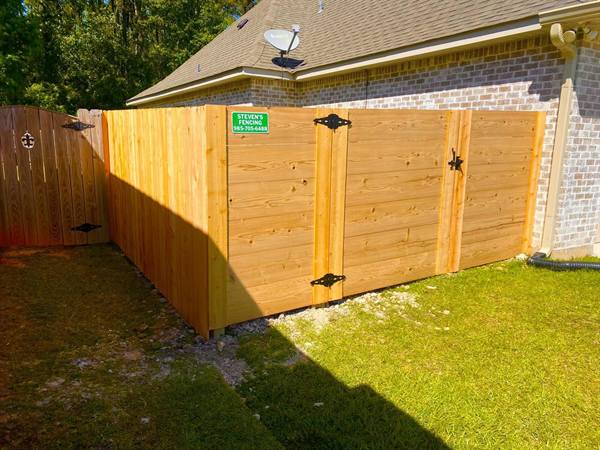 Horizontal-board cedar fence corner with gate