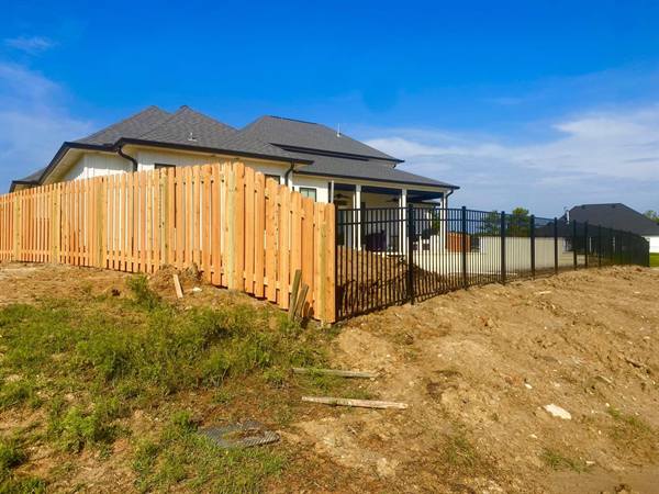 Picket fence meeting black aluminum at a new construction home