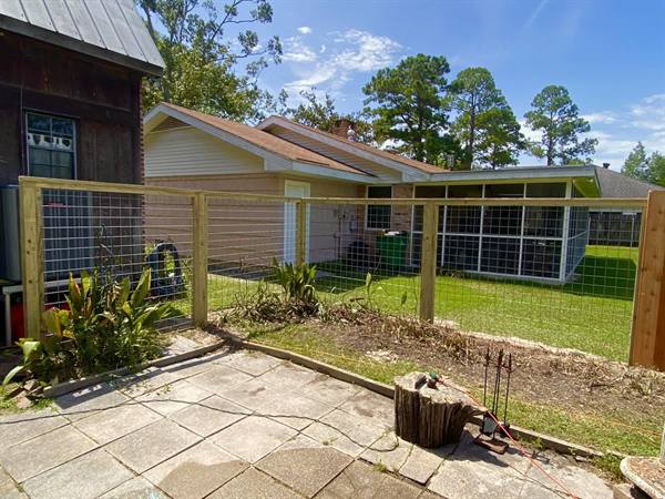 Wood-framed wire fence around a backyard patio
