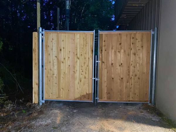 Steel-framed cedar double gate at a commercial drive