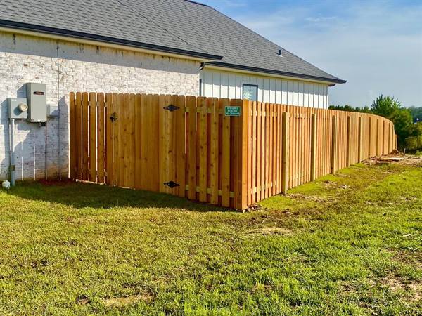 Shadowbox cedar fence with gate curving along a property line