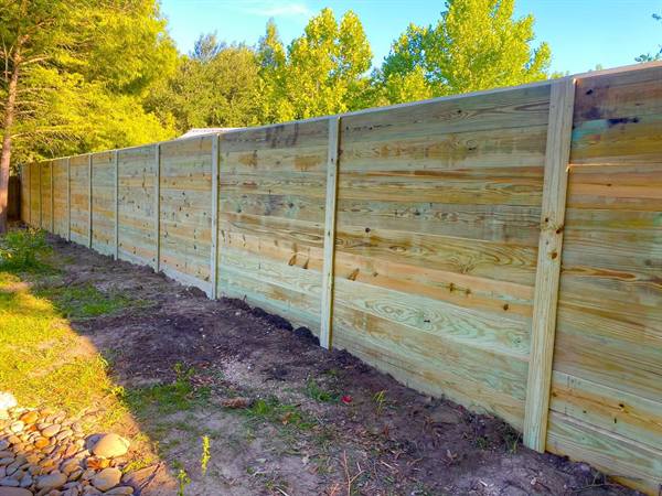Tall horizontal-board treated pine privacy fence