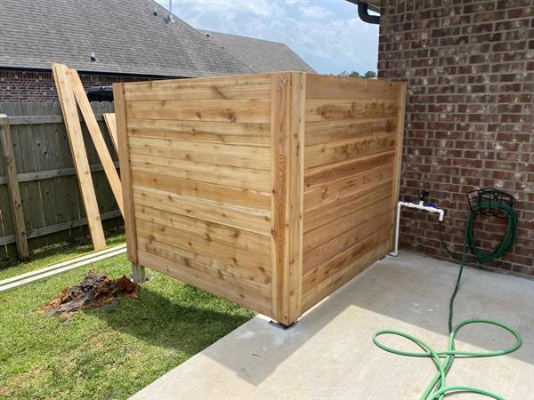 Horizontal cedar enclosure hiding pool equipment