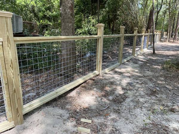 Framed wire fence panels along a shaded path