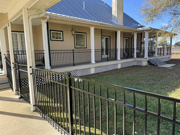 Black aluminum fence around a farmhouse porch