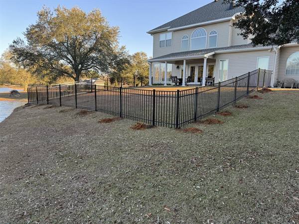 Black aluminum fence around a lakeside backyard